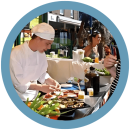 Kok bereidt eten op een drukbezocht buitenfestival of markt.